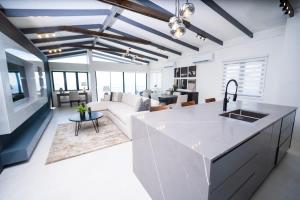 a kitchen and living room with a white counter top at Avaya Oasis - Villa Trinidad in Carenage