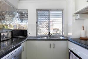 a kitchen with a sink and a microwave at Surfside Buddina Beachfront 3bed Apt - Direct Beach Access in Buddina +21 photos