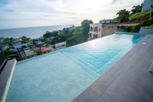a large swimming pool on the side of a building at Avaya Oasis - Suriname Suite in Carenage