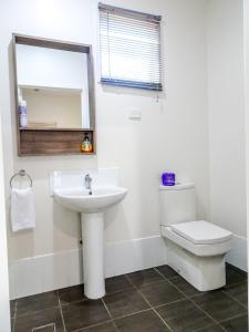 a bathroom with a sink and a toilet and a mirror at Sunlodge Caravan Park in Hervey Bay +14 photos