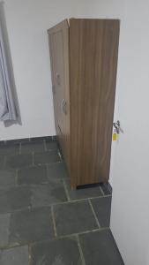 a wooden cabinet in the corner of a room at Quarto para 4 hóspedes in Itu
