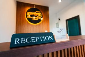 a sign on a reception desk in an office at on and on haus in Ban Na Nian +51 photos