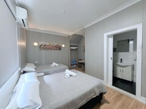 a hotel room with two beds and a sink at Alpine Heritage Motel in Goulburn