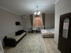 a bedroom with a bed and a couch in a room at Keruen in Taraz