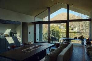 a living room with a table and a large window at Hiire IZU OMURO in Ito