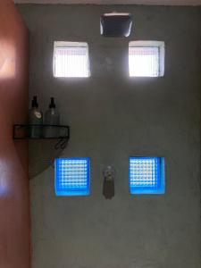 a bathroom with three blue lights on the wall at Calypso Loft in El Paredón Buena Vista