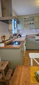 a kitchen with green cabinets and a wooden floor at La Solana in Ancillo +36 photos