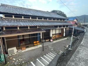 an asian house with a roof on a street at Ohana in Kuroshio