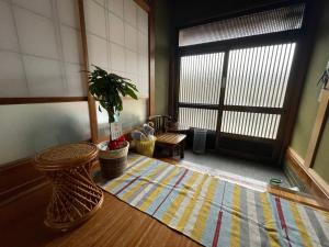 a room with a door and a potted plant on a rug at Ohana in Kuroshio