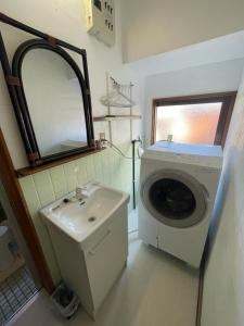 a bathroom with a washing machine and a sink at Ohana in Kuroshio