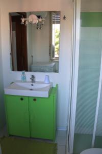 a bathroom with a green sink and a mirror at A Casa Mia Apartment in Catania