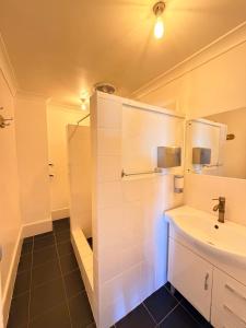 a bathroom with a sink and a shower at Alpine Heritage Motel in Goulburn +23 photos