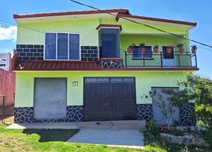 a yellow and black house with two garage doors at Mixtlaxotla Zacatlán Tours in Zacatlán