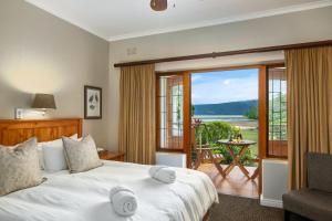 a bedroom with a large bed and a balcony at Waterfront Lodge in Knysna +73 photos