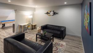 a living room with black leather furniture and a table at Oaktown Roost in Oakland
