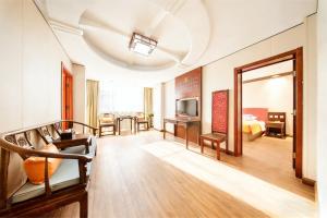 a living room with a couch and a television at 济南璞秀酒店-山东师范大学千佛山店Cultural Experience Hotel in Jinan
