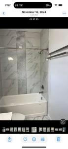 a bathroom with a white tub and a shower at Blessed Homes in East Orange