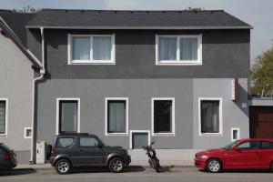 dos autos estacionados frente a una casa en Pension Casa Topolino en Wiener Neustadt