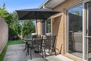 a table and chairs with an umbrella on a patio at The Buckleys Escape in Point Lonsdale