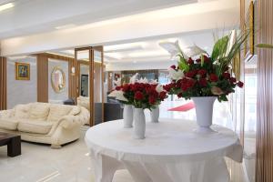 a living room with two vases with flowers on a table at GoldHome Apart Otel in Famagusta