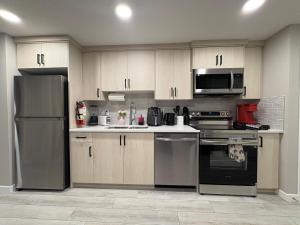 a kitchen with wooden cabinets and stainless steel appliances at Beyond comfort - arriveYYC in YYC +55 photos