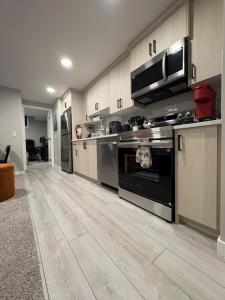 a large kitchen with a stove and a microwave at Beyond comfort - arriveYYC in YYC
