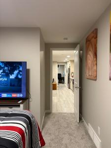 a room with a flat screen tv on a wall at Beyond comfort - arriveYYC in YYC