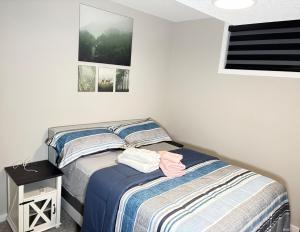 a bedroom with a twin bed and a night stand at Beyond comfort - arriveYYC in YYC