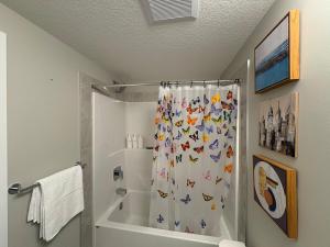 a bathroom with a shower curtain with animals on it at Beyond comfort - arriveYYC in YYC
