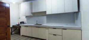 a kitchen with white cabinets and a sink at Pacific View Point in Matnog +23 photos