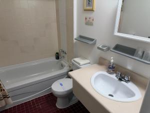 ein Badezimmer mit Waschbecken, Toilette und Badewanne in der Unterkunft Motel Rayalco in Laurier Station