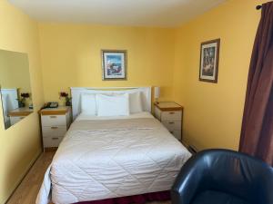 ein kleines Schlafzimmer mit einem Bett und einem Stuhl in der Unterkunft Motel Rayalco in Laurier Station + 21 Fotos