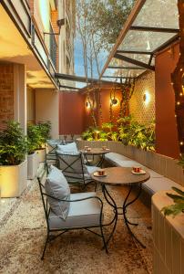 a patio with tables and chairs and plants at 5Q House Chapinero in Bogotá