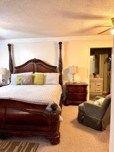 a bedroom with a large bed and a chair at The Tee Time Cottage in Augusta