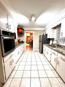 a kitchen with white cabinets and a tile floor at The Tee Time Cottage in Augusta +21 photos