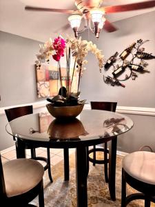 a dining room table with a vase of flowers on it at The Tee Time Cottage in Augusta