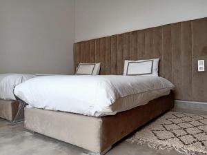 a bedroom with a large bed with a wooden headboard at Villa nomad marrakech in Douar bel Rhanodour +6 photos