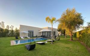 a house with a swimming pool in a yard at Villa nomad marrakech in Douar bel Rhanodour