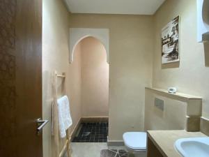a bathroom with a toilet and a sink at Villa nomad marrakech in Douar bel Rhanodour
