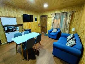 a living room with a blue couch and a table at Siloe in Coihaique