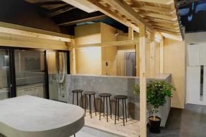 a kitchen with a table and some bar stools at MATSUMOTO CASTLE hostel in Matsumoto +21 photos