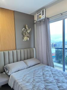 a bedroom with a bed with a teddy bear on the wall at Primavera Citta Verde in Balulang