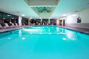 a large swimming pool with blue water in a building at Holiday Inn Express Big Rapids by IHG in Big Rapids