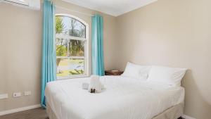 a bedroom with a large white bed with a window at Boater's Retreat - pet friendly, right off the M1 in Toormina