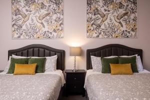 two beds sitting next to each other in a bedroom at Oaktown Roost in Oakland