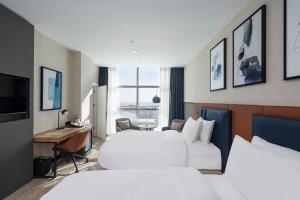 a hotel room with two beds and a desk at Crowne Plaza Istanbul West-Beylikduzu By IHG in Istanbul +201 photos