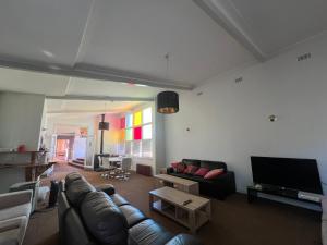 a living room with a couch and a flat screen tv at Bunkhouse Motel Cooma in Cooma