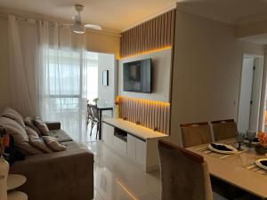 a living room with a couch and a table at Apartamento em Bertioga com varanda gourmet Brisas da enseada in Bertioga