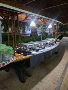 a long table with plates and dishes on it at Kaengkrachan Diamond Green Resort in Ban Song Phi Nong