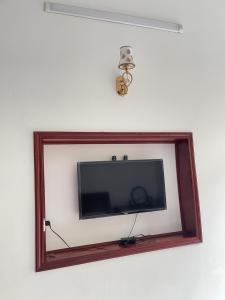 a flat screen television in a wooden frame on a wall at Anna's House - Hoa Lư in Ninh Binh